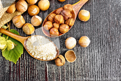 Image of Flour and hazelnuts in two spoons on board top