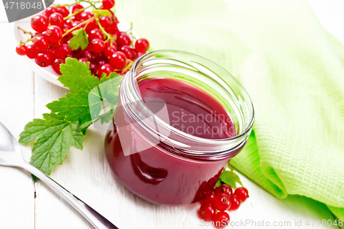 Image of Jam of red currant in jar on white wooden board