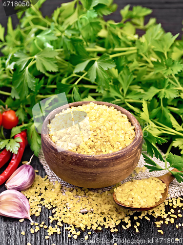 Image of Bulgur in bowl with vegetables on wooden board