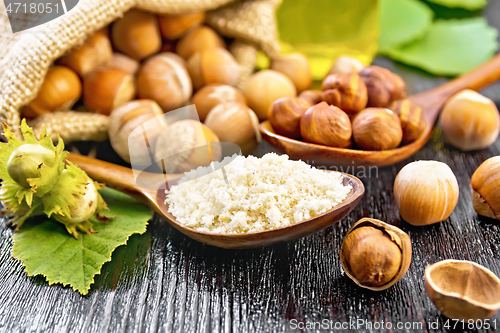 Image of Flour and hazelnuts in two spoons on board