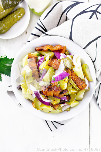 Image of Salad potato with bacon and cucumber in plate on light board top