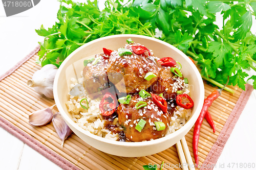 Image of Meatballs in sweet and sour sauce with rice on bamboo napkin