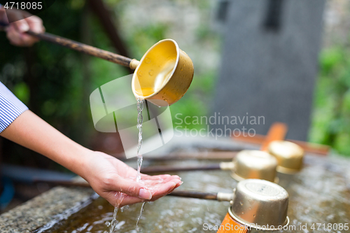 Image of Woman washing hand in water fountain