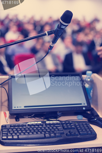 Image of laptop computer and microphone at podium