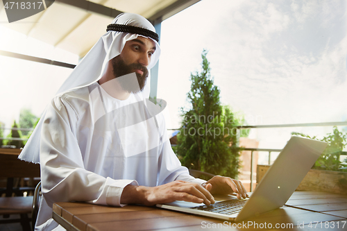 Image of Arabian saudi businessman working outdoors