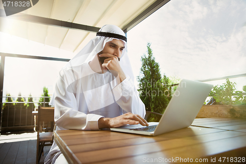 Image of Arabian saudi businessman working outdoors