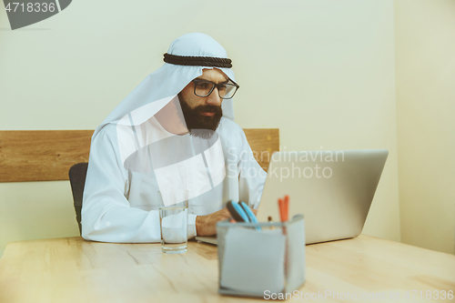 Image of Arabian saudi businessman working in office