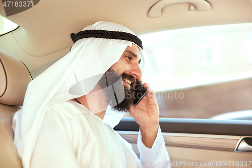 Image of Arabian saudi businessman working in his car