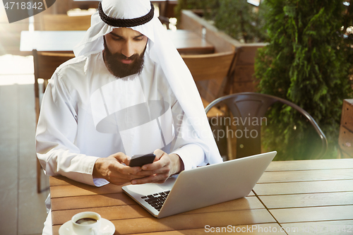 Image of Arabian saudi businessman working outdoors