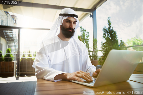 Image of Arabian saudi businessman working outdoors