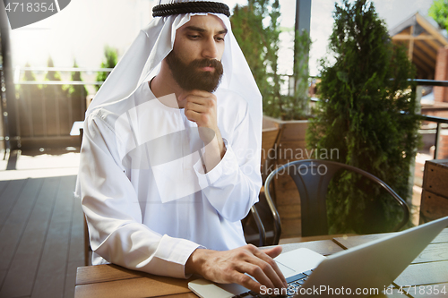 Image of Arabian saudi businessman working outdoors