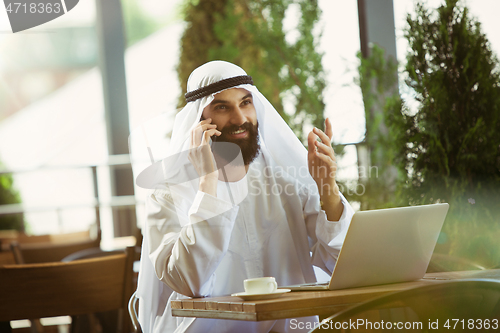 Image of Arabian saudi businessman working outdoors