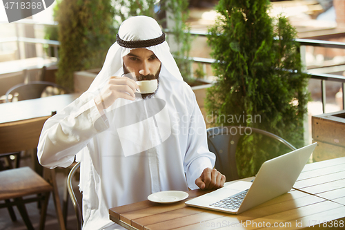 Image of Arabian saudi businessman working outdoors