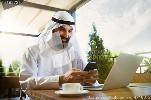 Image of Arabian saudi businessman working outdoors