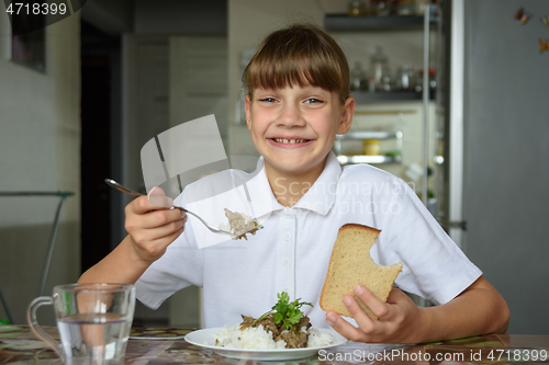 Image of Happy girl happily eats the second dish and looks into the frame with a cute smile