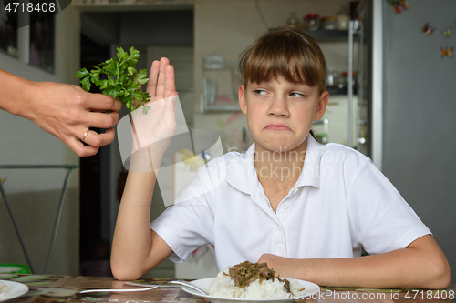 Image of The girl does not want to eat fresh herbs at lunch