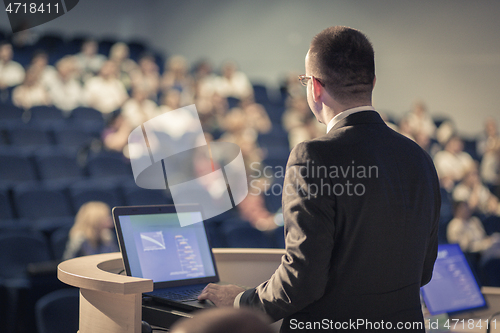 Image of Public speaker giving talk at business event.