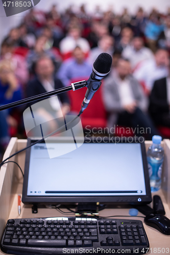 Image of laptop computer and microphone at podium