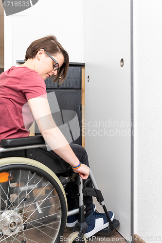 Image of disabled woman opens a door in her flat