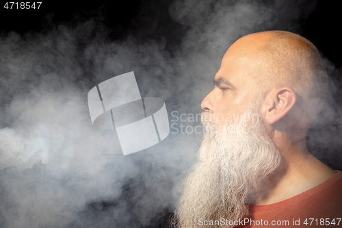 Image of bearded man gets smoke in his face portrait