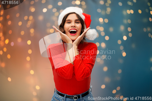 Image of happy young woman in santa hat on christmas