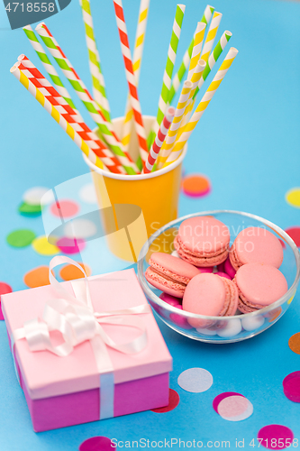 Image of birthday gift, macarons and paper straws for party