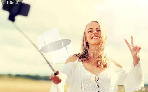 Image of happy young woman taking selfie by smartphone