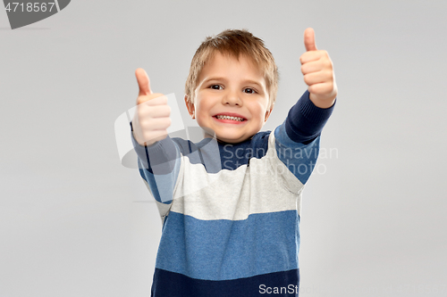 Image of little boy in striped pullover showing thumbs up