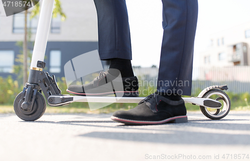 Image of young businessman with electric scooter outdoors