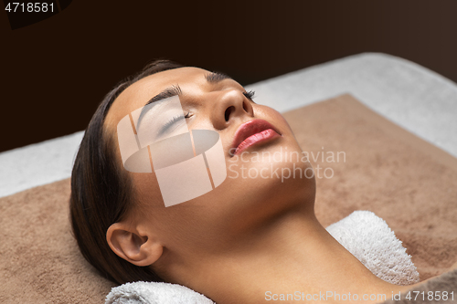 Image of young woman lying at spa or massage parlor