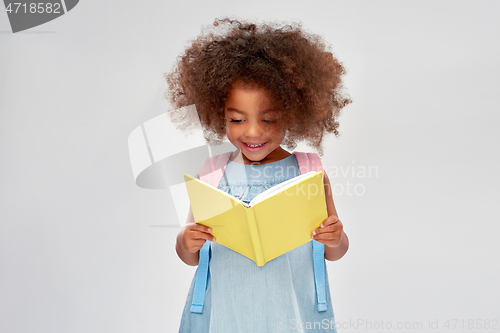 Image of happy little african girl reading book