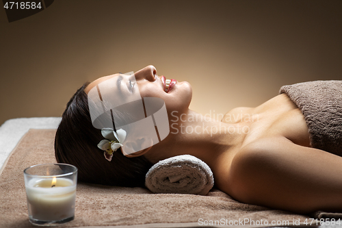 Image of young woman lying at spa or massage parlor