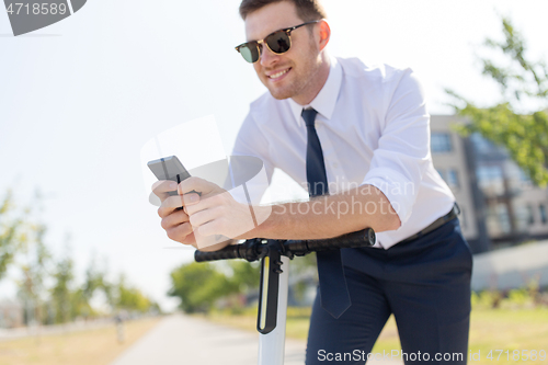 Image of businessman with smartphone and electric scooter