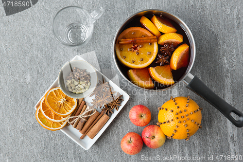 Image of pot with hot mulled wine, orange slices and spices