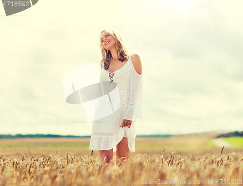 Image of smiling young woman in white dress on cereal field