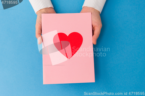 Image of hands holding greeting card with heart