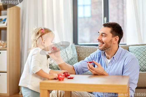 Image of father and daughter playing tea party at home