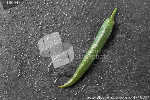 Image of green chili pepper on slate stone background