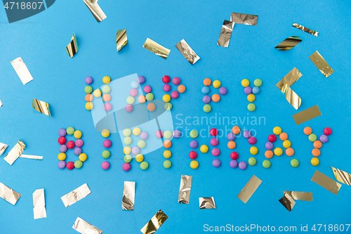 Image of happy birthday of candies and confetti on blue