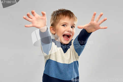 Image of portrait of scared little boy in striped pullover