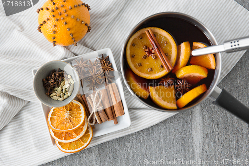 Image of pot with hot mulled wine, orange slices and spices