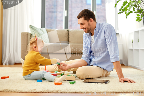 Image of father playing with little baby daughter at home