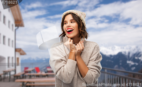 Image of woman in winter hat and sweater at ski resort