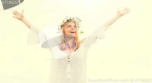 Image of happy young woman in flower wreath on cereal field