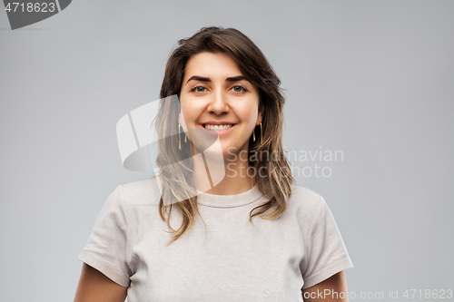 Image of happy smiling young woman in grey t-shirt