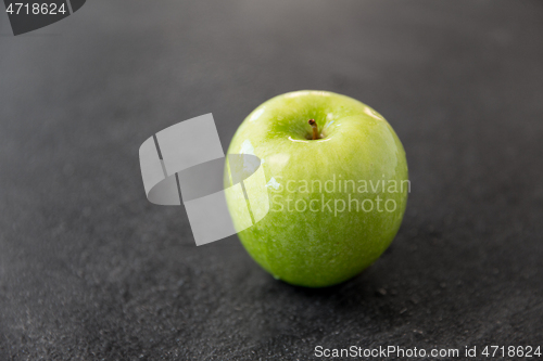 Image of ripe green apple on slate stone background