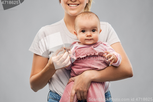 Image of happy young mother holding little baby daughter