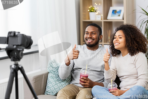 Image of couple of video bloggers with camera at home