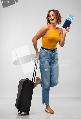 Image of happy young woman with air ticket and travel bag