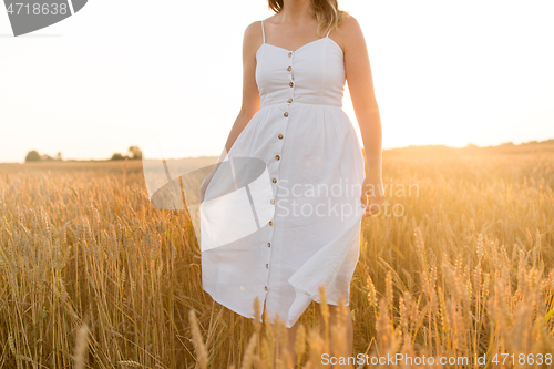 Image of woman in white dress walking along cereal field